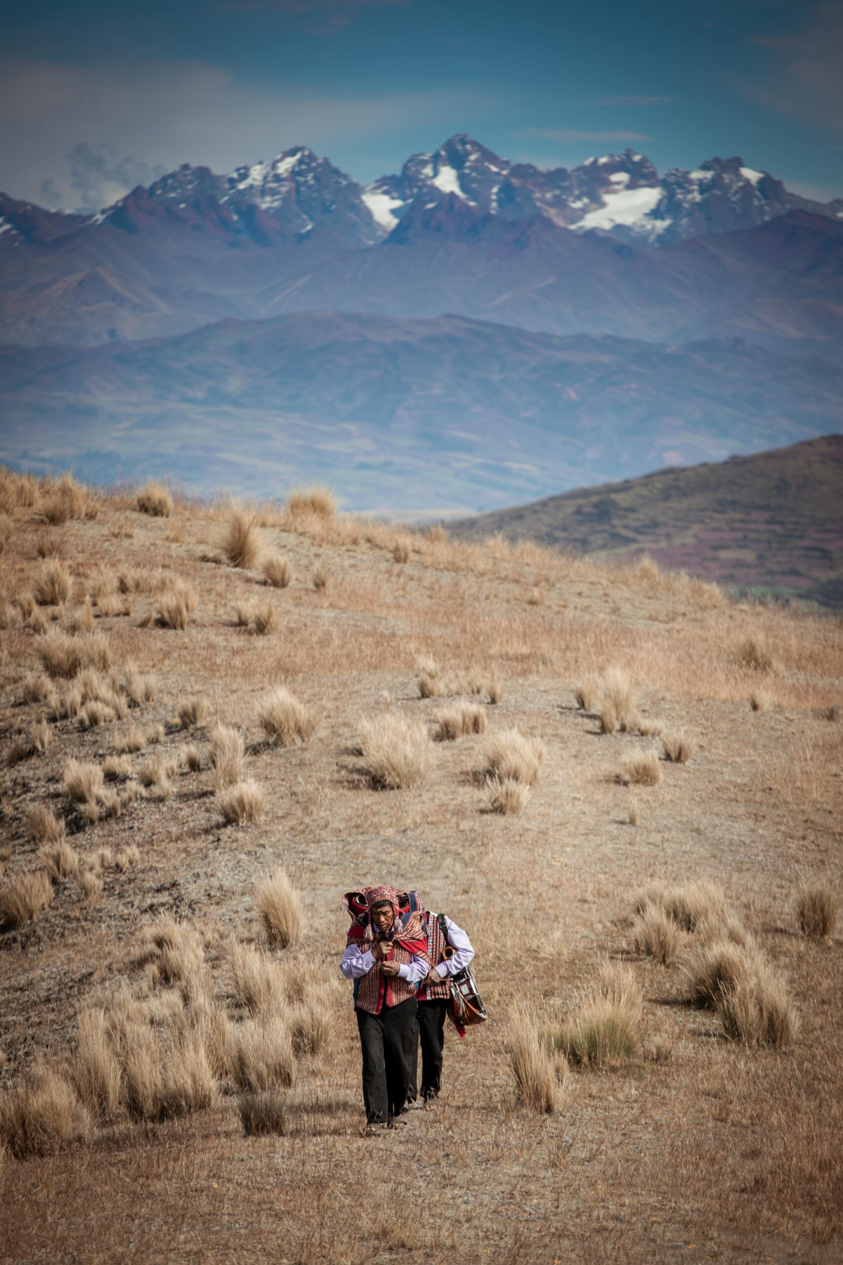 A group of hikers trekking through the rugged terrain of Cusco's Andes Mountains.