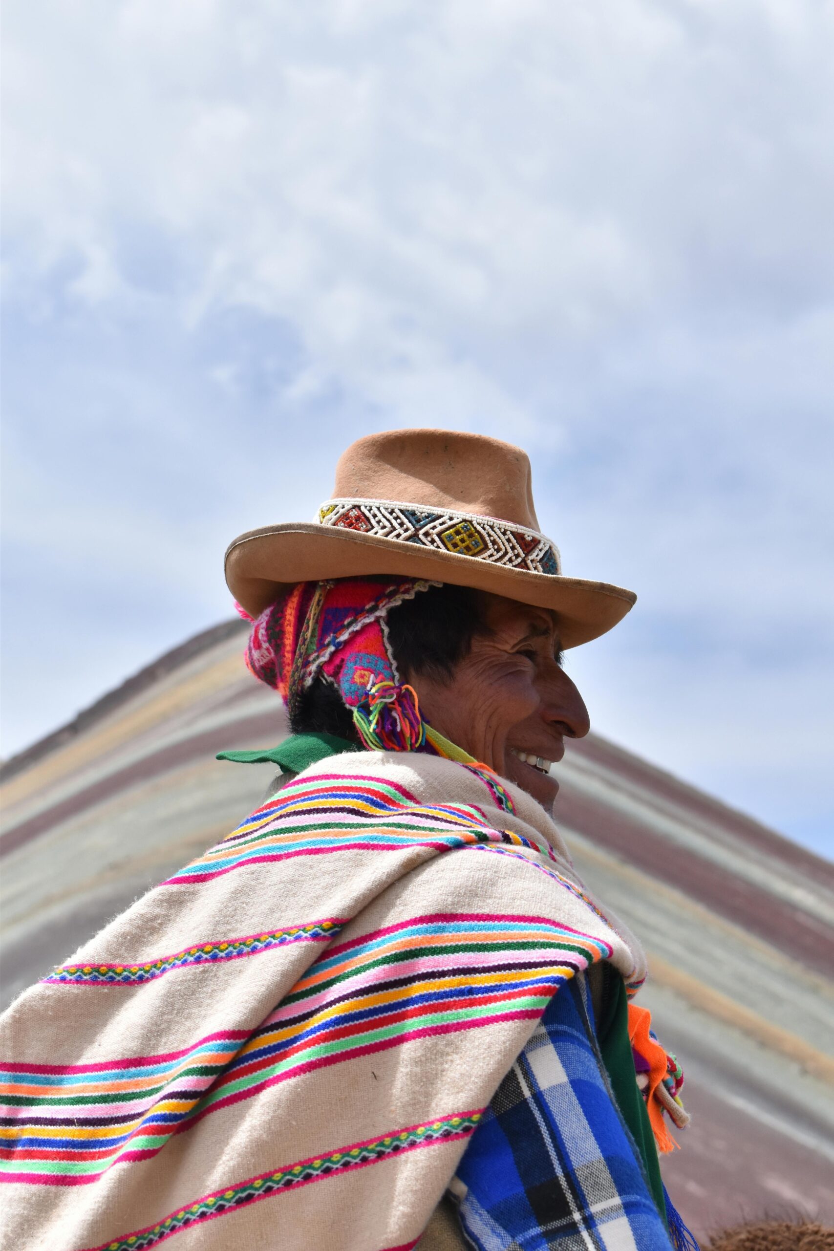 Vibrant portrait of a local Peruvian man in traditional attire against the backdrop of Rainbow Mountain.